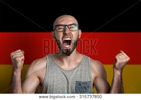 Emotion Of Anger And Indignation. The Man In Glasses Clenched His Hands Into Fists And Screams. In T