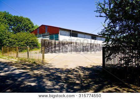 A Large Old Abandoned Farm Building, Was Used As A Cowshed, Summer Landscape In Thuringia, Germany