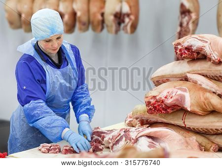 Cutting Meat In Slaughterhouse At The Meat Manufacturing.