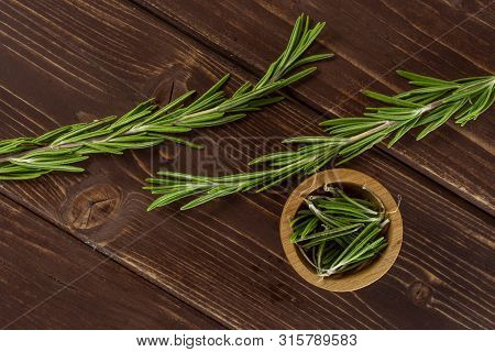 Group Of Two Whole Lot Of Pieces Of Fresh Evergreen Sprig Of Rosemary In A Wooden Bowl Flatlay On Br