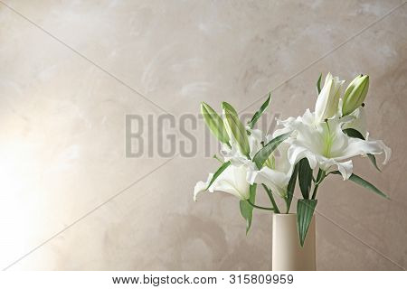Vase With Beautiful Lilies On Light Brown Background, Space For Text