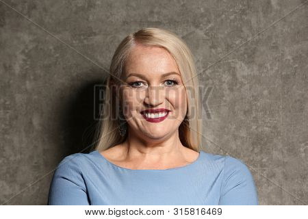 Portrait Of Beautiful Mature Woman On Grey Background