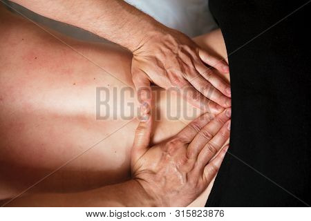 The Hands Of The Specialist Are Making A Massage In A Massage Room. Health Concept