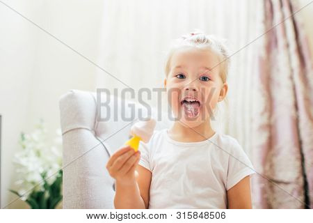 Aborable Smiling Blonde 3 Years Baby Girl Eating Homemade Ice Cream And Showing Her Tongue