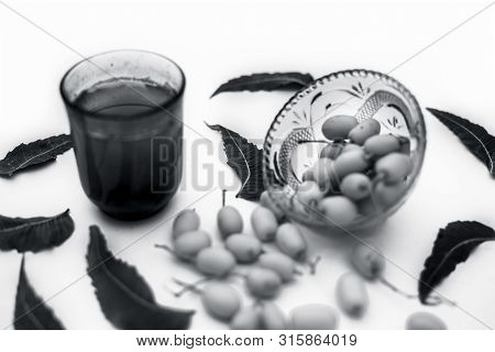 Detox Or Detoxifying Drink Of Neem Fruit In A Glass Isolated On White Along With Some Neem Fruit Or
