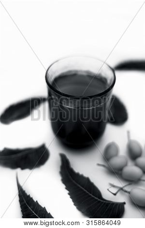 Detox Or Detoxifying Drink Of Neem Fruit In A Glass Isolated On White Along With Some Neem Fruit Or