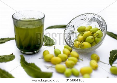 Detox Or Detoxifying Drink Of Neem Fruit In A Glass Isolated On White Along With Some Neem Fruit Or