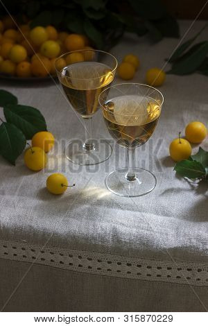 Cherry Plum Liqueur In Small Glasses And Cherry Plum On A Wooden Background. Rustic Style.