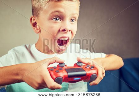 Hands using video game controller, on the couch at home