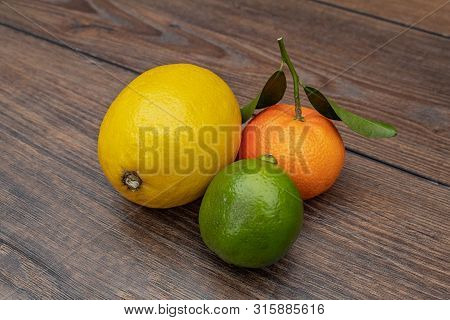 Lemon, Lime And Mandarin On A Wooden Table