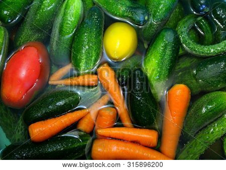 Cucumbers, Tomatoes, Carrots In The Water. Washing Colorful Vegetables Before Salting, Cooking.