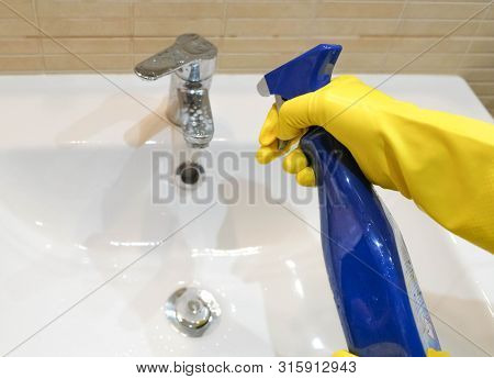 Woman In Yellow Rubber Gloves Holding Cleaning Spray For Cleaning A Water Tap. Housewife Holding A R