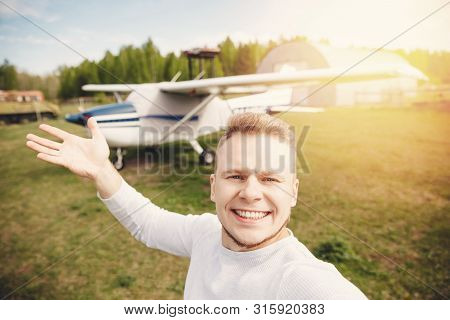 Happy Male Pilot Selfie Photo Aviator Smiling On Background Propeller Driven Aircraft. Travel Rental