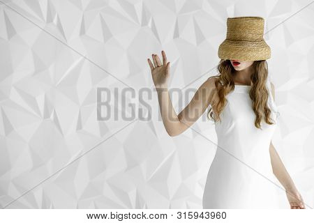 Young Woman Moving Her Hand Gingerly As Her Eyes Are Covered With Hat