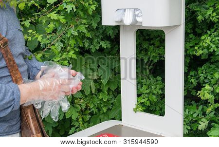 The Man With Two Hands Take Cellophane Gloves On The Gas Station.
