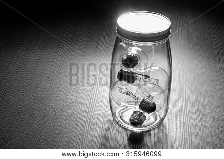Glass Jar With Light Bulbs On Wooden Background