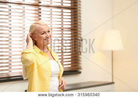 Portrait Of Happy Mature Woman Near Window Indoors