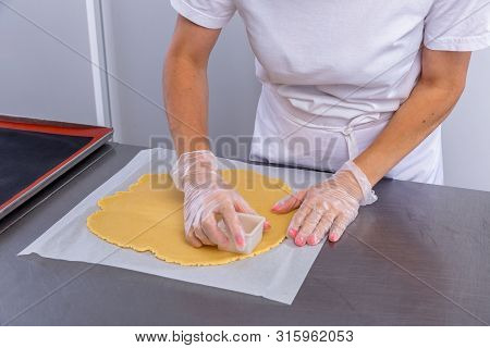 Pastry Chef In The Kitchen Makes Cookies. Cook Cuts Cookies From Rolled Dough Using A Cookie Cutter.