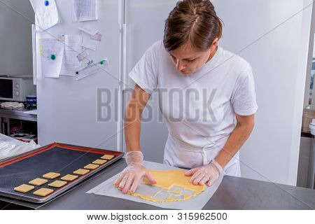 Pastry Chef In The Kitchen Makes Cookies. Cook Cuts Cookies From Rolled Dough Using A Cookie Cutter.