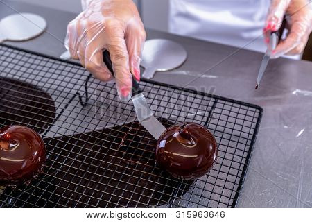 The Pastry Chef In The Kitchen Glazes Pastries. Cook Puts Glazed Cakes On Decorative Coasters. Maste
