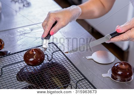 The Pastry Chef In The Kitchen Glazes Pastries. Cook Puts Glazed Cakes On Decorative Coasters. Maste