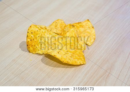The Pieces Of Corn Chip On Wooden Table