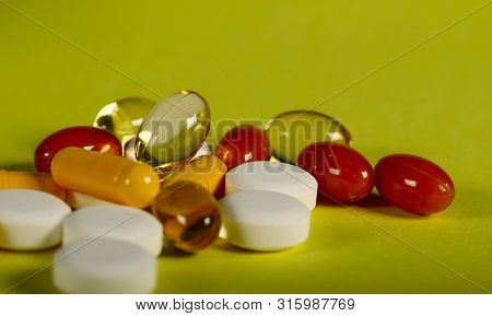 A Lot Of Bright Medicine Pills On A Yellow Background. Cropped Shot, Vertical, Side View, Close-up, 