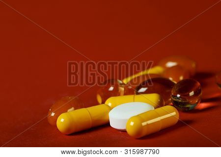 A Lot Of Bright Pills Of Drugs On A Red Background. Cropped Shot, Horizontal, Side View. The Concept