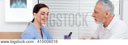 Mature Man Talking To Smiling Rehabilitologist During Consultation, Banner.