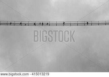 Black White Picture Of People On A High Suspension Bridge Cloudy Sky