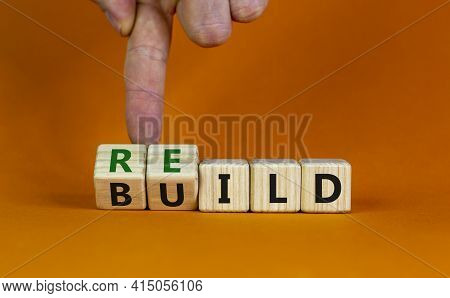 Rebuild Symbol. Concept Word 'rebuild' On Wooden Cubes On A Beautiful Orange Table. Businessman Hand