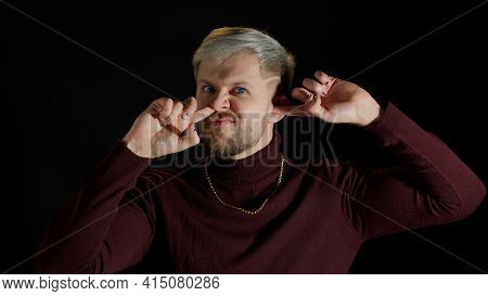 Funny Stupid Stylish Young Man With Blue Eyes Picking Nose And Ear With Silly Smiling Humorous Expre