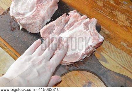 Salted And Peppery Steak Lies On A Wooden Stand