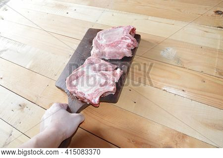Salted And Peppery Steak Lies On A Wooden Stand