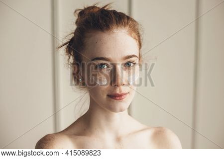 Ginger Woman Wearing Hydrogel Eye Patches Looking At Camera With Bare Shoulders
