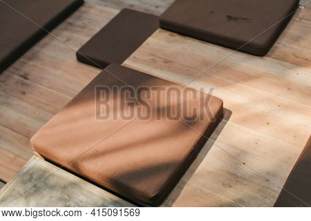 Japanese Sitting Cushion With Sunlight Rays On A Wooden Floor In A Restaurant.