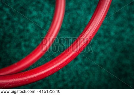 Blurred Background Covering The Playground, Red Pipes Bent In A Semicircle On A Structure For Climbi