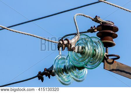 Electric Pole Against The Blue Clear Sky. Three-phase Power Line To Turn.