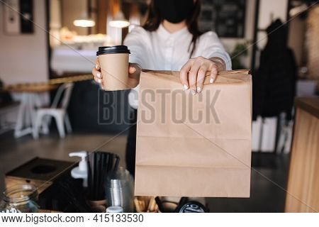 Female Cashier With Face Mask Serving Coffee And Food To Customer, Shop Open After Lockdown. Woman H