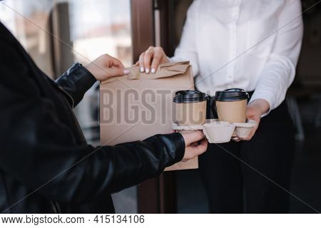 Female Cashier In Face Mask Serving Coffee And Package With Food To Customer. Coffee Shop Open After