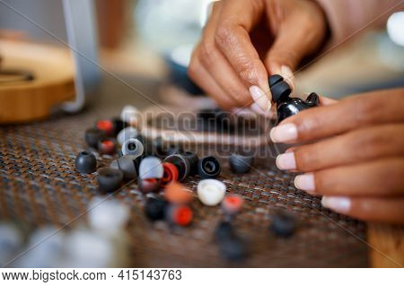 Woman choosing ear pads in audio store, music fan