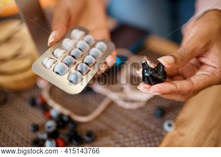 Woman choosing ear pads in audio store, music fan