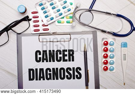 On A Light Wooden Background There Is Paper With The Inscription Cancer Diagnosis, A Stethoscope, Co