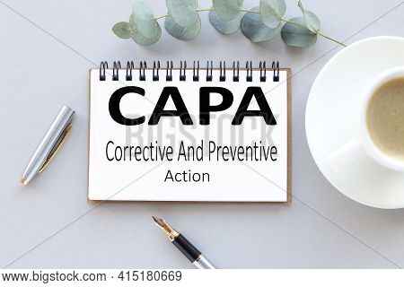 Capa Corrective And Preventive Action Plans. Text On White Notepad Paper. Near Cups With Coffee And 
