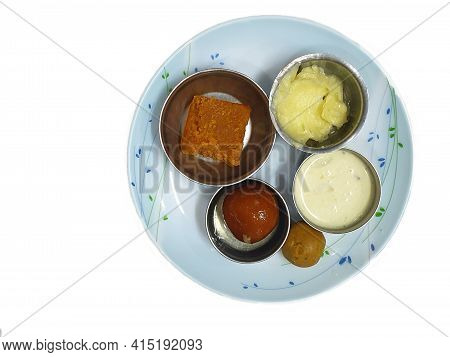 Five Different Indian Sweets Like Barfi, Laddoo, Shrikhand, Kheer And Gulab Jamun Served In A Plate.