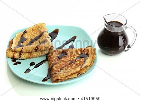 หวาน pancakes บนแผ่นกับนมข้นที่แยกต่างหากบนพื้นสีขาว