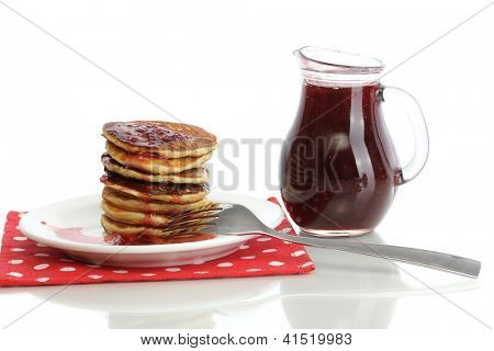 หวาน pancakes บนแผ่นกับนมข้นที่แยกต่างหากบนพื้นสีขาว