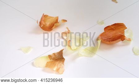Peels Of Yellow Onion Falling Down The Table During Cooking, Peeling Onion For Making Homemede Food