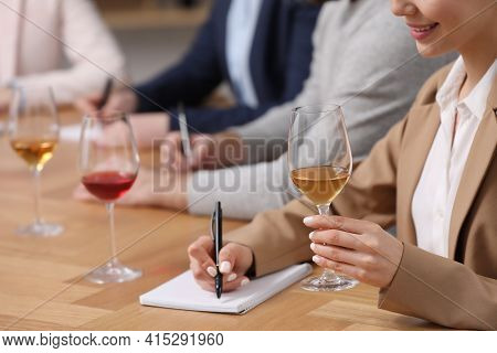 Sommeliers Tasting Different Sorts Of Wine At Table Indoors, Closeup