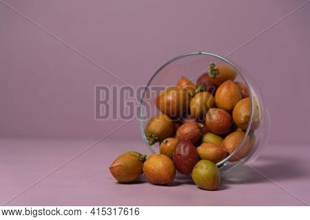 Caferana Fruits (bunchosia Armeniaca) In Natura Served In A Bowl On A Pink Background.